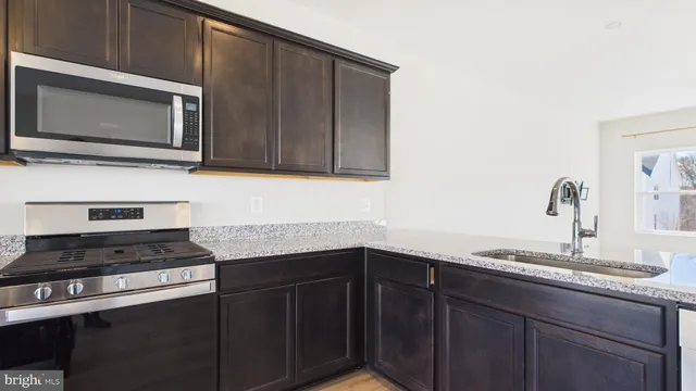 a view of a bedroom with wooden floor chandelier fan and windows