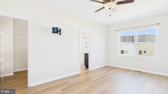 a view of a room with wooden floor and a ceiling fan