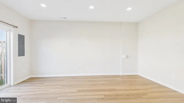 a kitchen with stainless steel appliances kitchen island granite countertop a refrigerator a stove top oven a sink dishwasher and wooden cabinets with wooden floor