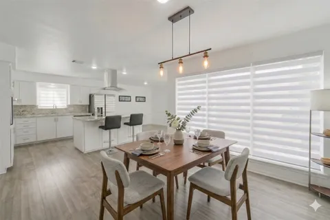 a kitchen with stainless steel appliances granite countertop kitchen island wooden floors and white cabinets