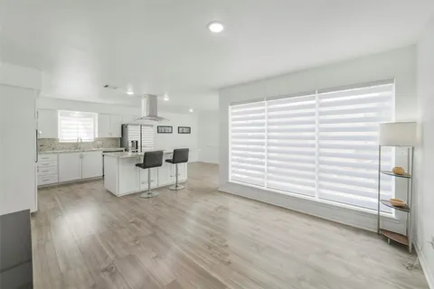 a kitchen with a sink dishwasher a stove and white countertops with wooden floor