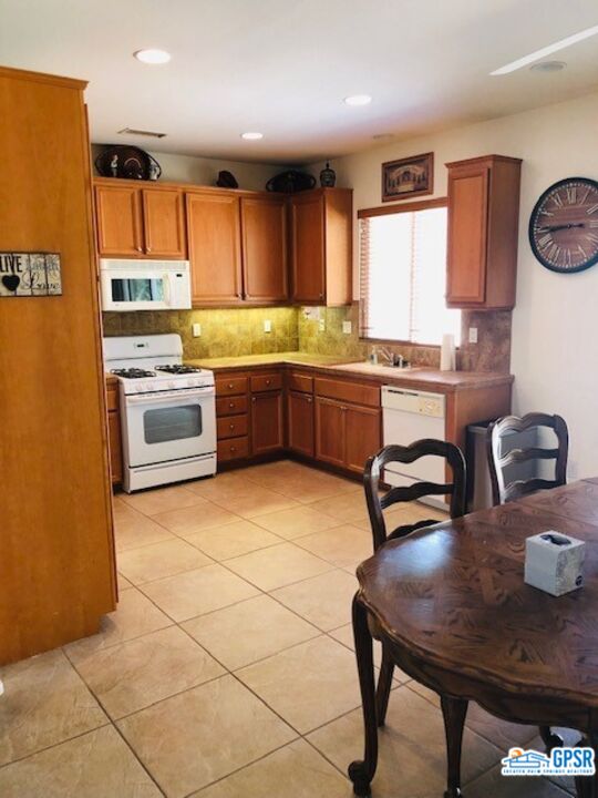 40 Shoreline Drive Rancho Mirage, CA 92270 - Photo 11 of 22 a kitchen with stainless steel appliances granite countertop a stove a sink dishwasher and a refrigerator with wooden cabinets