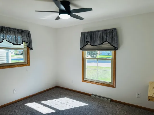 an empty room with wooden floor and a window