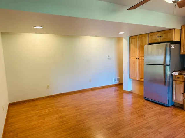 a view of an empty room with wooden floor