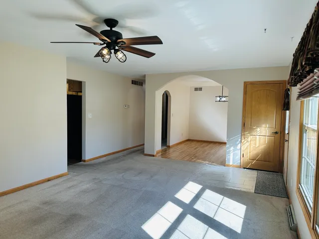 a view of a livingroom with a ceiling fan and window