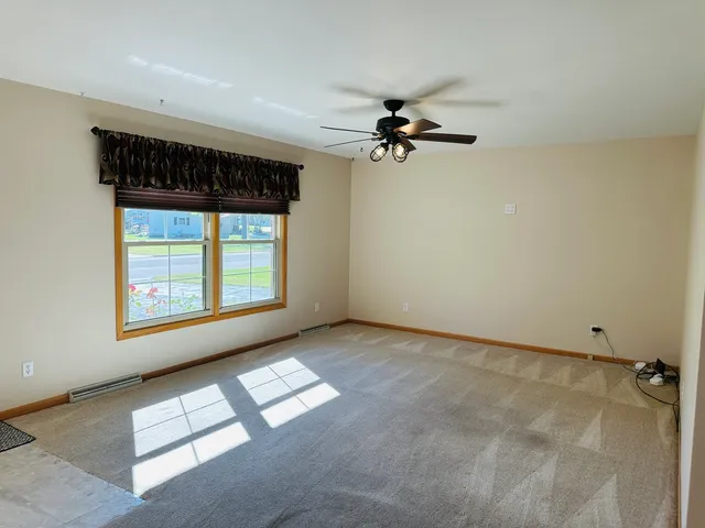 a view of empty room with wooden floor and window