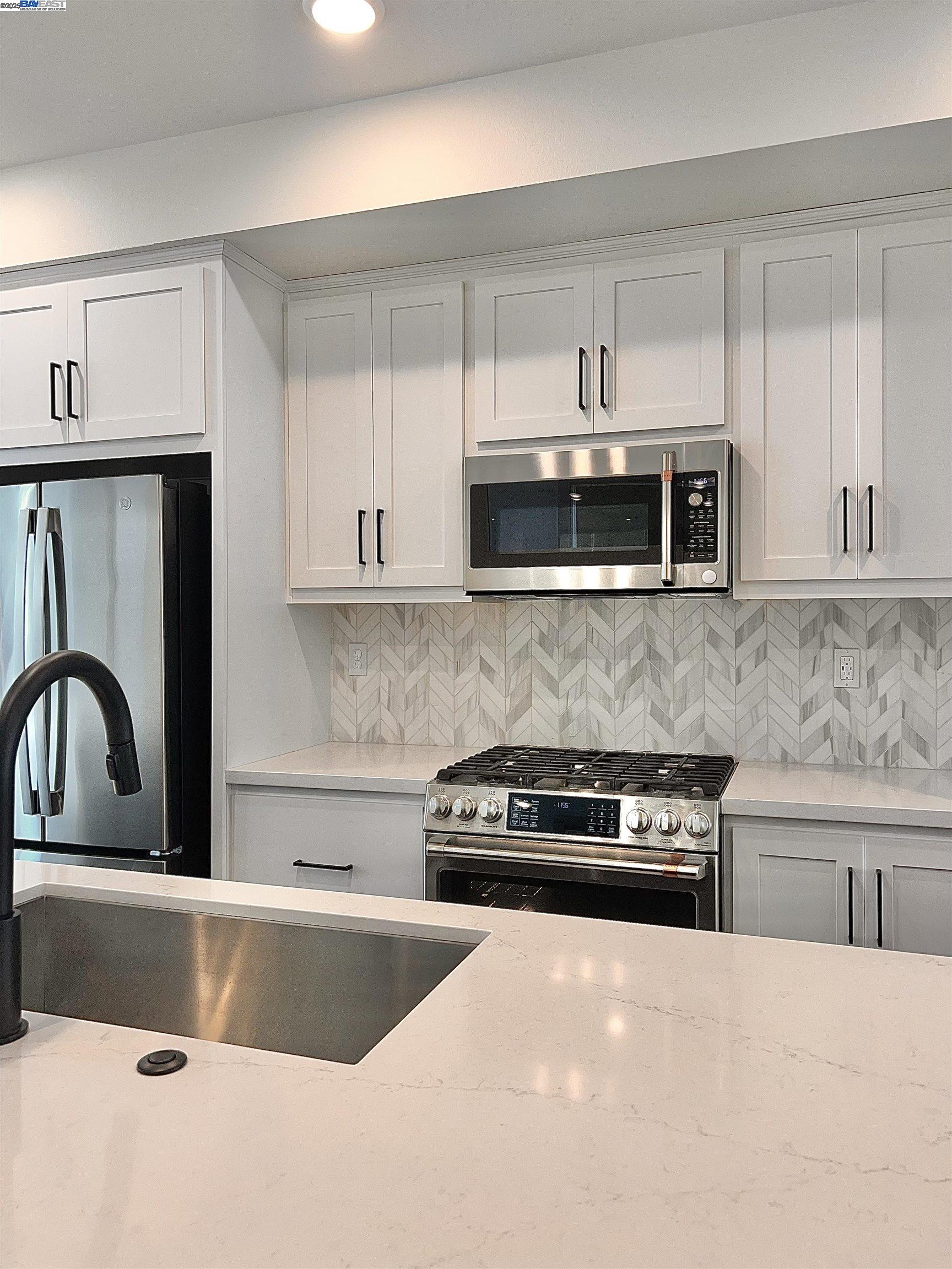 1712 17th Street Oakland, CA 94607 - Photo 12 of 31 a kitchen with granite countertop a stove a microwave a sink and cabinets
