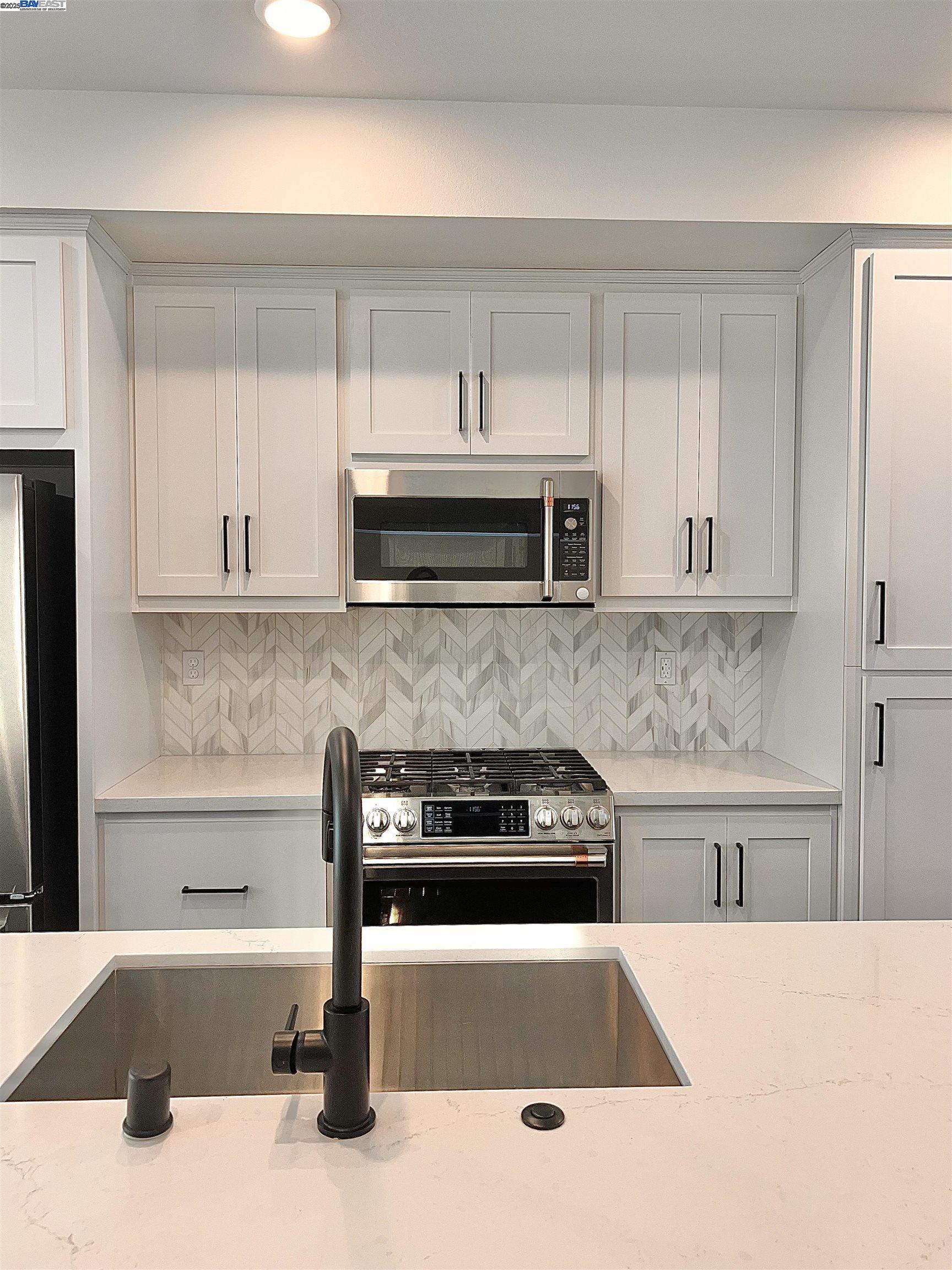 1712 17th Street Oakland, CA 94607 - Photo 13 of 31 a kitchen with a sink and white cabinets