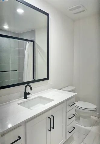 a bathroom with a sink toilet a mirror and vanity