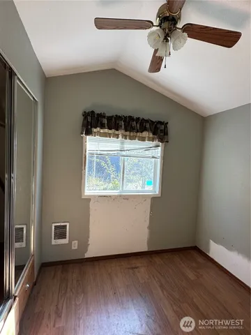 a large kitchen with granite countertop a sink and dishwasher a stove top oven with wooden floor