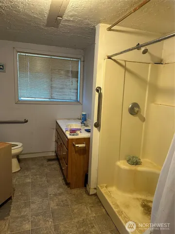 a bathroom with a granite countertop sink toilet and shower