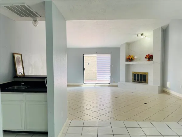 a view of an empty room with window and hardwood floor