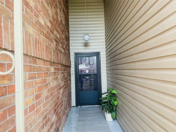 a view of an empty room with window and chandelier
