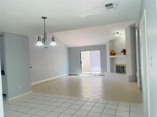 a view of an empty room with window and fireplace