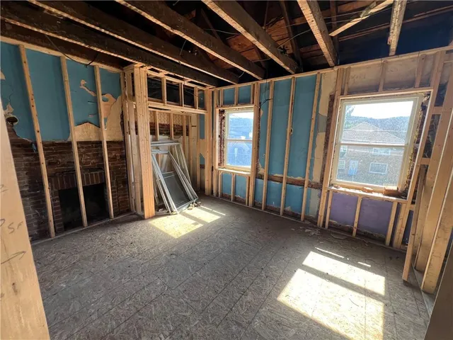 a view of an empty room with wooden walls and stairs