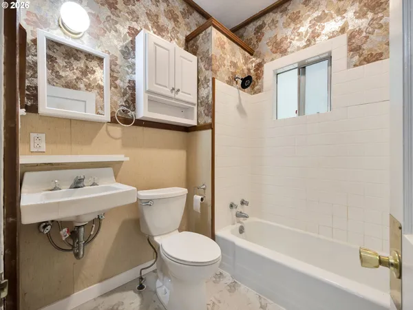 a white toilet sitting next to a bath tub
