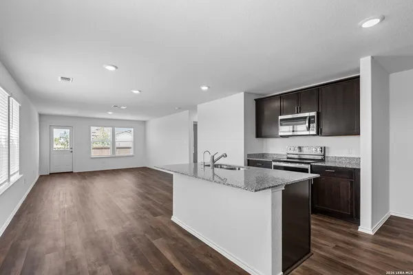 a kitchen with stainless steel appliances granite countertop a stove a sink and a microwave