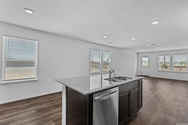 a kitchen with stainless steel appliances granite countertop a sink and a granite counter tops with wooden floors