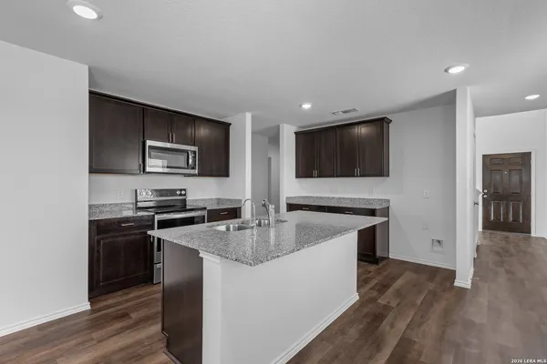 a kitchen with stainless steel appliances granite countertop a stove a sink and a microwave