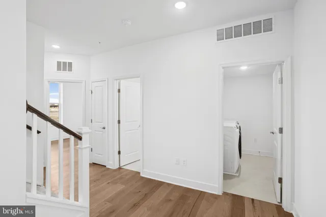 a view of a hallway with wooden floor and entryway