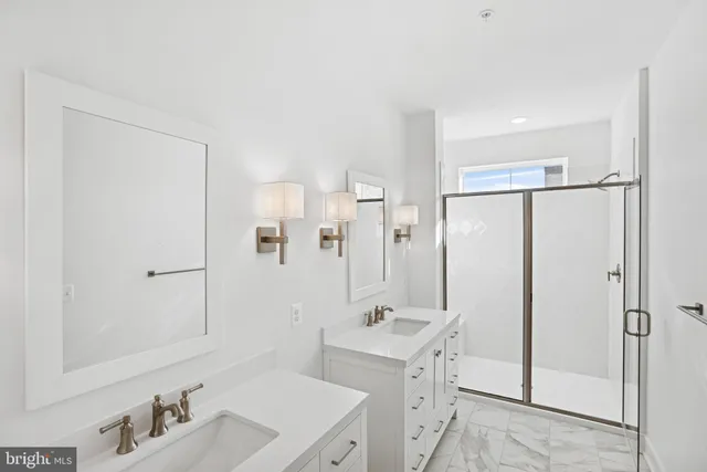 a bathroom with a double vanity sink mirror and shower