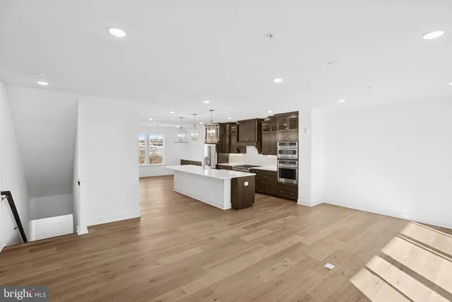 a large white kitchen with a large window and stainless steel appliances