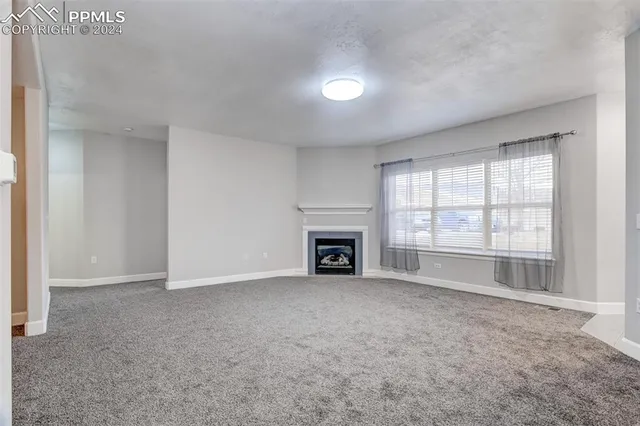 an empty room with fireplace and windows