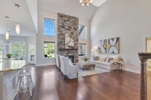 a kitchen with stainless steel appliances granite countertop a dining table chairs stove refrigerator and cabinets