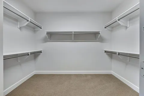 a view of staircase with railing and white walls