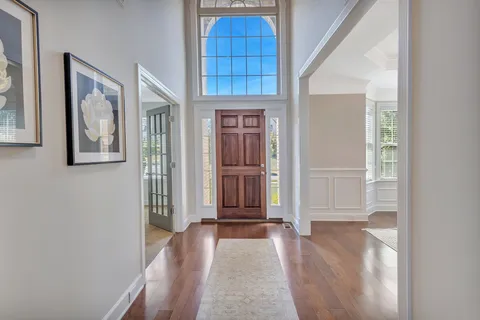 a view of a dining room with furniture a chandelier and wooden floor