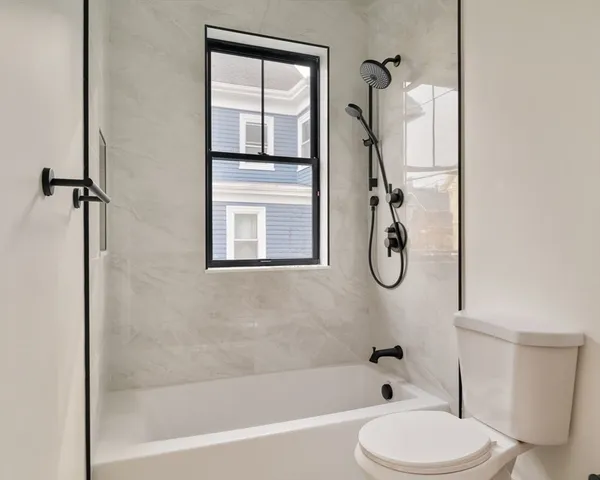 a bathroom with a toilet tub and shower
