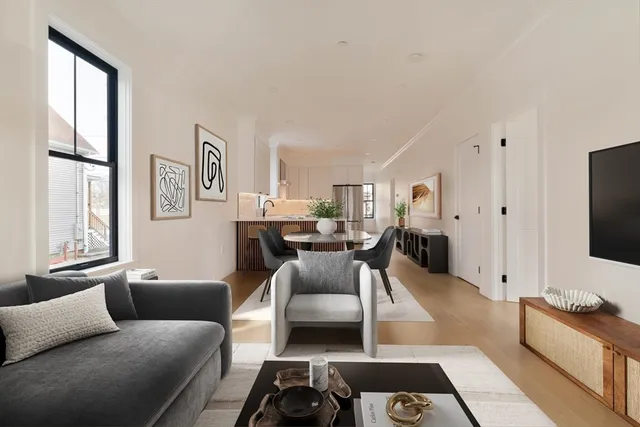 a living room with furniture a large window and a flat screen tv