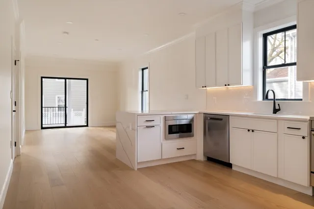 a kitchen with stainless steel appliances a sink a stove and white cabinets