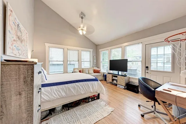 a spacious bedroom with a bed and wooden floor