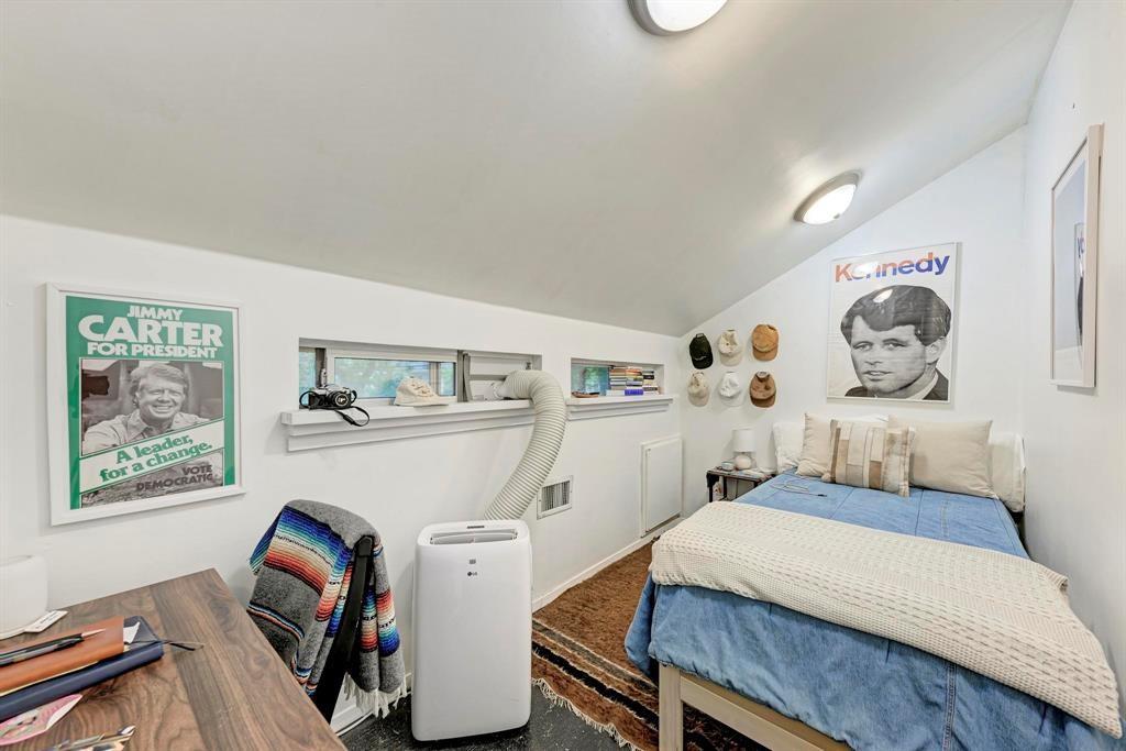 2834 Salado Street Austin, TX 78705 - Photo 18 of 40 a bedroom with a bed and wooden floor