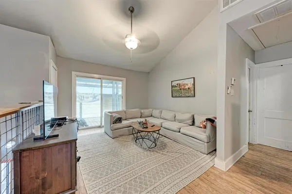 a living room with furniture kitchen view and a chandelier