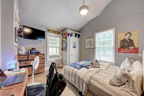 a bedroom with a bed and wooden floor
