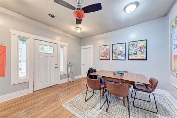 a dining room with wooden floor and a ceiling fan