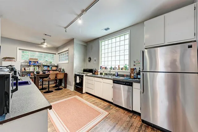 a kitchen with a refrigerator a stove a sink dishwasher and a refrigerator with wooden floor