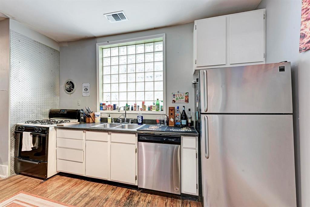 2834 Salado Street Austin, TX 78705 - Photo 9 of 40 a kitchen with white cabinets and white appliances