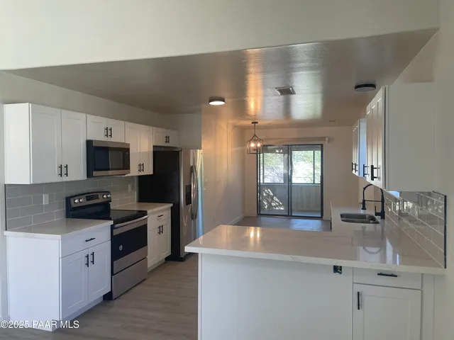 a kitchen with stainless steel appliances a sink stove and refrigerator