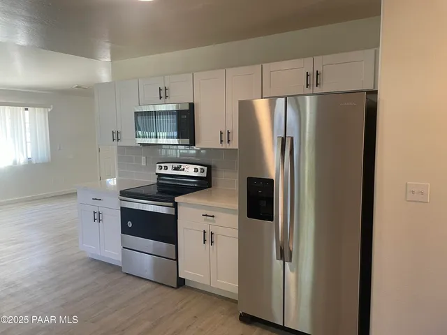 a kitchen with stainless steel appliances a refrigerator stove and microwave