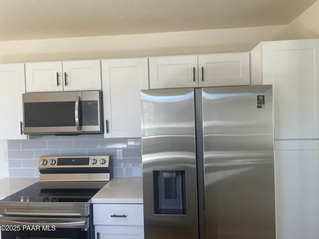 a kitchen with a refrigerator and a stove top oven