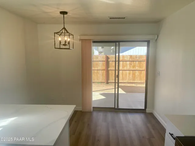 a view of empty room with wooden floor and window