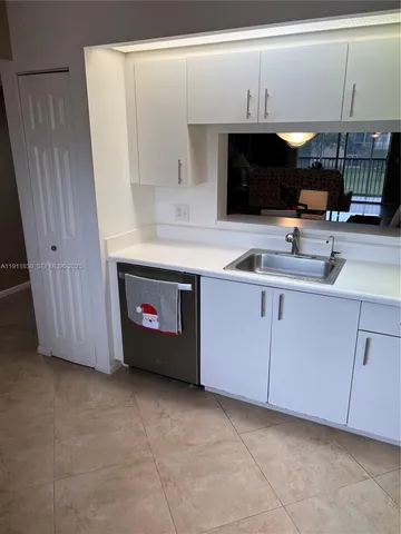 a kitchen with stainless steel appliances a sink cabinets and wooden floor
