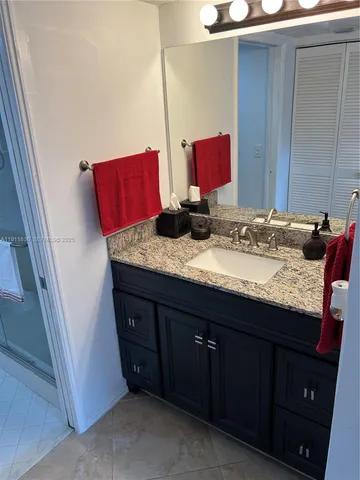 a bathroom with a granite countertop sink and a mirror