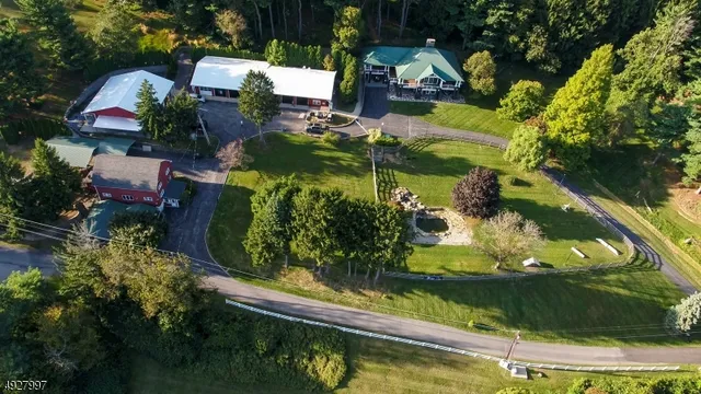 an aerial view of a house with a yard lake lake and trees all around