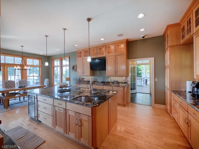 a kitchen with stainless steel appliances kitchen island granite countertop a stove a sink and a wooden floors