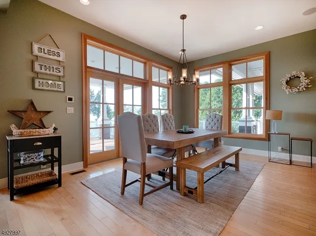 a living room with furniture a dining table and a floor to ceiling window