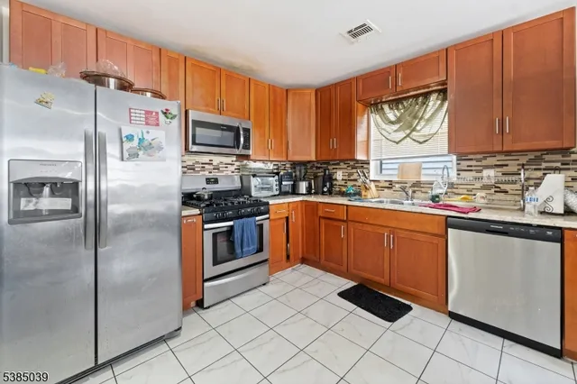 a kitchen with stainless steel appliances granite countertop a refrigerator sink and cabinets